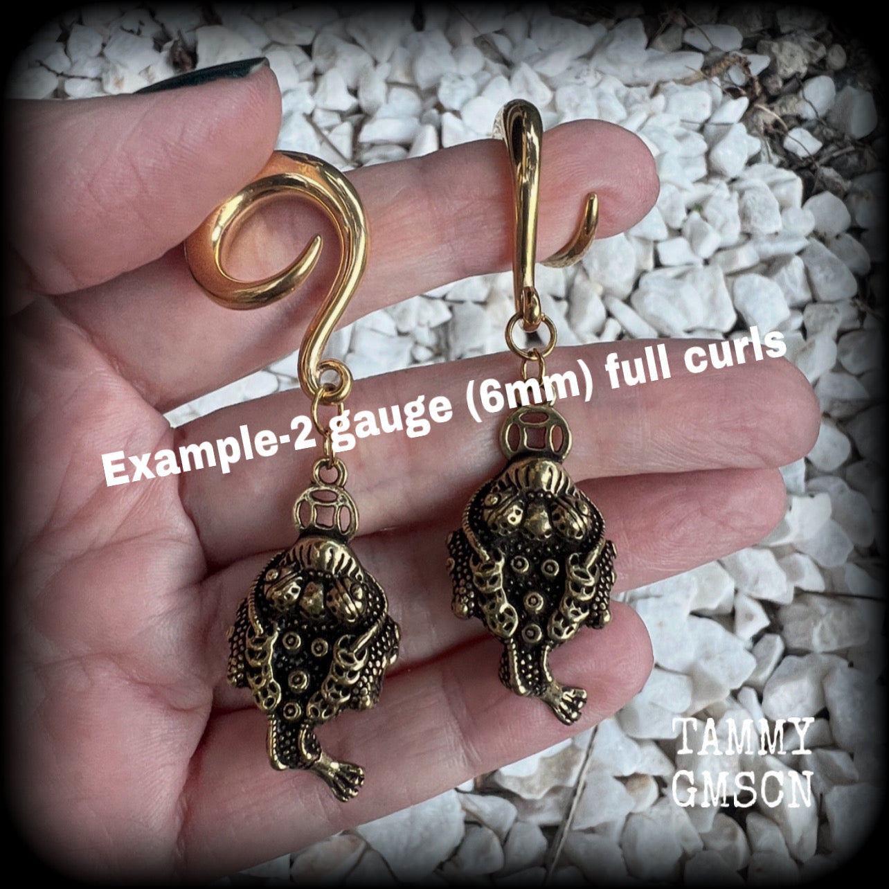🔥 The three-legged golden toad is a mythological animal in China known to bring prosperity, treasure and wealth. To attract wealth, always have the money toads’ head facing you, and never away from you 🔥

These awesome brass ear hangers feature unique three legged brass money toads, measuring just on 7.5cms from tip to tip, and weighing approx 19 grams each.

This pair has been made on 2 gauge (6mm) titanium coated surgical steel full curls, suitable for stretched lobes.

