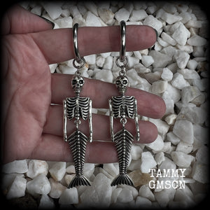 These gorgeous dangly earrings feature antique silver mermaid skeletons, measuring approx 10.5 cms from tip to tip, and weighing approx 14 grams a piece .

These earrings have been made on strong silver alloy snap hoop rings, to be worn in stretched lobes with silicone earlets from 2 gauge (6mm).