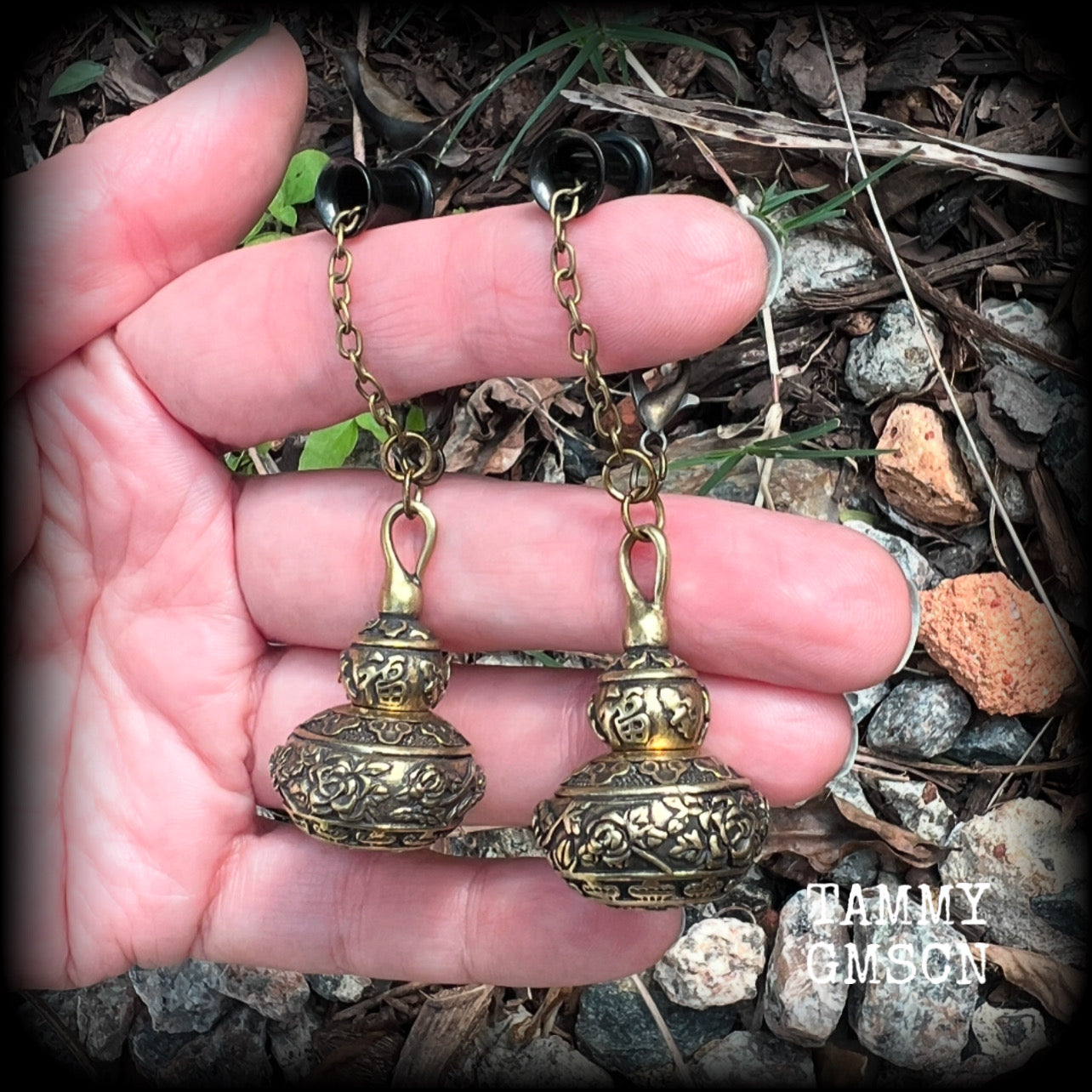 These brass stash pot tunnel dangles are gorgous! 
Featuring tibetan sanscrit and beautiful rose details, these earrings weigh in at approx 17 grams each, and nice and dangly, measuring in at just over 7cm from tip to tip.

These open up (as shown) so you can stash spell affirmations, drugs, precious pet ashes, anything you like really...

💥This listing includes one pair of surgical steel single flared O-ring earlets