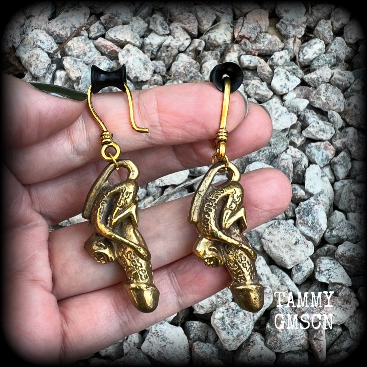Featuring a brass Paladkhik penis charm, worn to attract love sex wealth and success and to protect from evil, these unique earrings weigh 19 grams each and measure just over 6cms from tip to tip.

This pair have been made on small antique antique gold shephard hooks, to be worn through stretched ears with silicone earlets from 8 gauge (3mm).