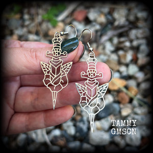 This pair of stainless steel earrings feature a classic punk rose and dagger tattoo design, measuring just on 6.5cms from tip to tip, and weighing only a grams or two each.

This pair has been made on stainless steel french hooks, suitable for pierced ears.