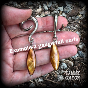 These gorgeous gauged earrings feature beautiful polished sea shell slivers, weighing in approx 10 grams a piece, and measuring approx 7cms from tip to tip.
This pair has been made on 2 gauge (6mm) surgical steel full curl hooks, to be worn in stretched lobes.