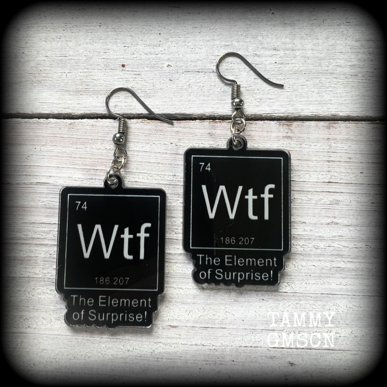 This cheeky pair of earrings features acrylic letter tiles showing the chemical element of Wtf, the Element of Surprise!!!
Measuring just over 6cms from tip to tip, these earrings weigh only a few grams each.

This pair has been made with stainless steel french hooks, suitable for pierced ears.