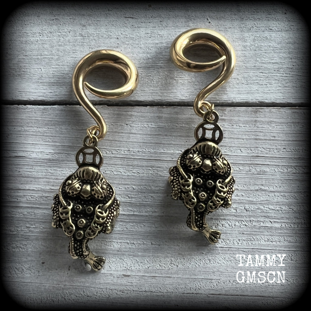 🔥 The three-legged golden toad is a mythological animal in China known to bring prosperity, treasure and wealth. To attract wealth, always have the money toads’ head facing you, and never away from you 🔥

These awesome brass ear hangers feature unique three legged brass money toads, measuring just on 7.5cms from tip to tip, and weighing approx 19 grams each.

This pair has been made on 2 gauge (6mm) titanium coated surgical steel full curls, suitable for stretched lobes.

