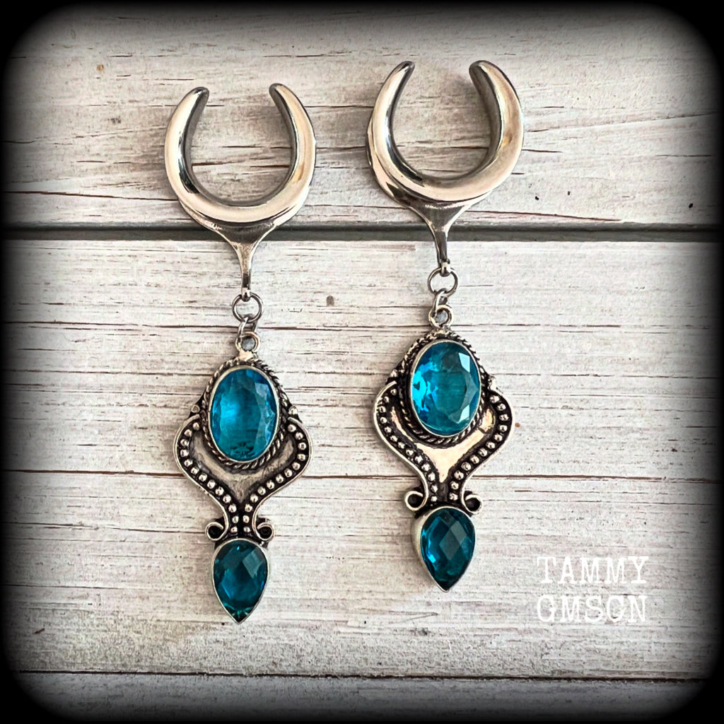These earrings feature gorgeous facet blue topaz gemstones in a beautiful boho antique silver setting, lovely and dangly at just on 8cms from tip to tip, and not too heavy at 12 grams each.

These earrings have been made on 3/4” gauge (19mm) surgical steel cradles, to be worn in stretched lobes.