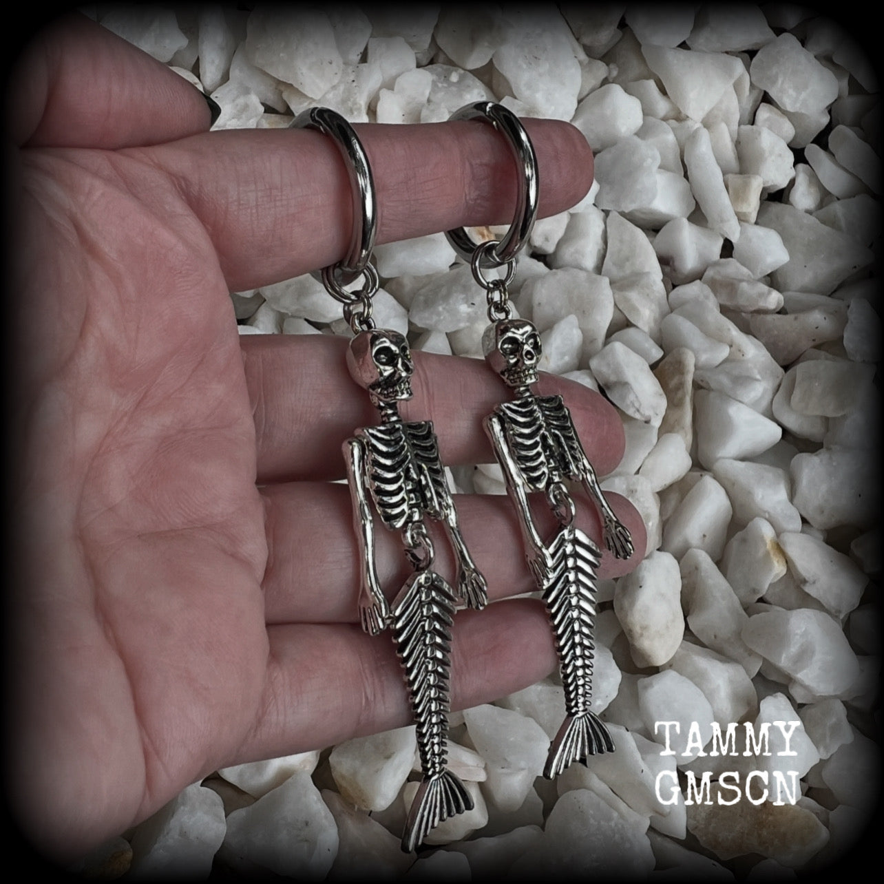 These gorgeous dangly earrings feature antique silver mermaid skeletons, measuring approx 10.5 cms from tip to tip, and weighing approx 14 grams a piece .

These earrings have been made on strong silver alloy snap hoop rings, to be worn in stretched lobes with silicone earlets from 2 gauge (6mm).