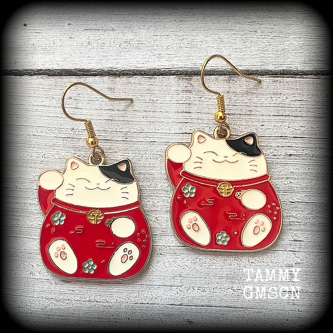 Featuring red and white maneki neko cat charms, theses earrings measure just under 5cms from tip to tip, and weigh only a few grams each.

This pair have been made with antique gold french hooks, suitable for pierced ears.
