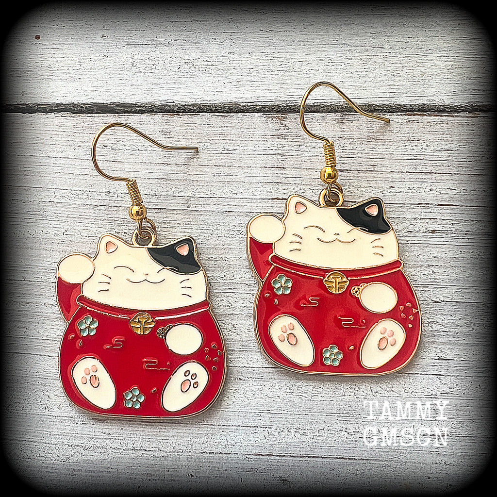 Featuring red and white maneki neko cat charms, theses earrings measure just under 5cms from tip to tip, and weigh only a few grams each.

This pair have been made with antique gold french hooks, suitable for pierced ears.