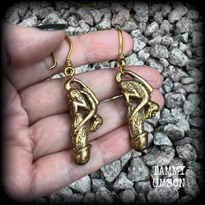 Featuring a brass Paladkhik penis charm, worn to attract love sex wealth and success and to protect from evil, these unique earrings weigh 19 grams each and measure just over 6cms from tip to tip.

This pair have been made on small antique antique gold shephard hooks, to be worn through stretched ears with silicone earlets from 8 gauge (3mm).