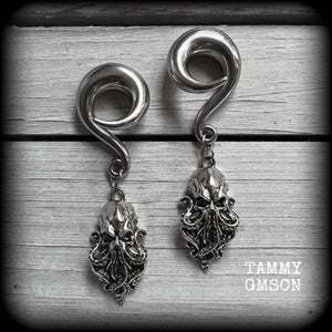 Featuring awesome dangly antique silver Cthulhu charms, these awesome gauged earrings weigh in at 29 grams a piece, and measure just on 8.5 from tip to tip.

This pair has been made on 00 gauge (10mm) surgical steel full curl hooks, to be worn in stretched lobes.

If you would like these made for pierced ears or smaller gauges and dont see them in our Sea Shanty & Sea Hag range, please get in touch.