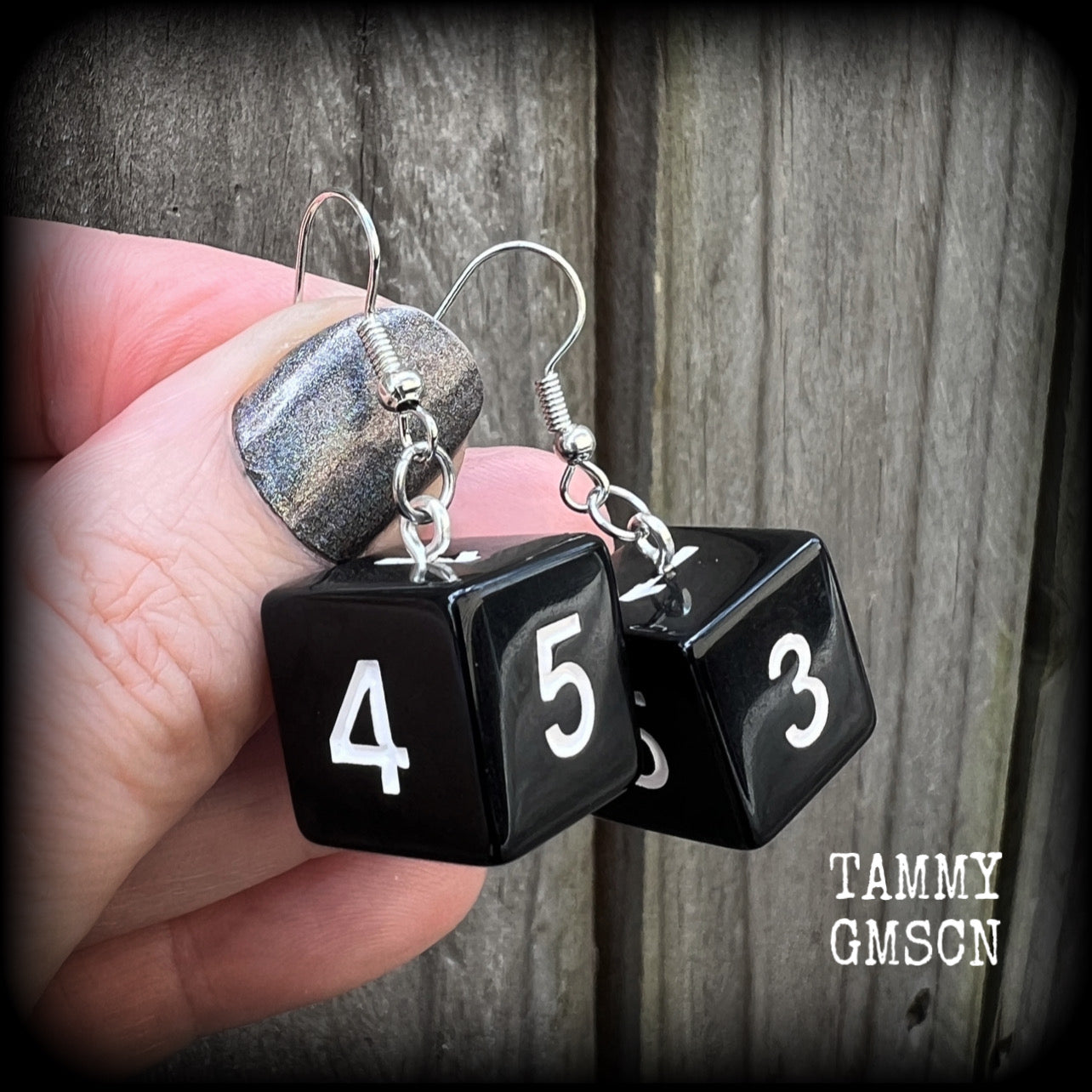 Featuring a pair of pitch black gamer dice, these super nerdy earrings measure just on 4cm from tip to tip and weigh approx 5 grams each.

This pair have been made with stainless steel french hooks, suitable for pierced ears.