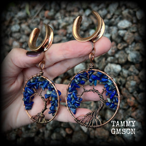 These beautiful Tree of life gauged earrings feature gorgeous wire wrapped trees with beautiful blue lapis lazuli gemstone chips, super dangly measuring just over 10cms from tip to tip, and weighing approx 20 grams each.
This pair has been made on 1” gauge (25mm) surgical steel cradles, suitable for stretched lobes.