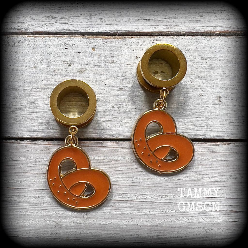 These adorable tunnel earrings feature classic enamel and antique gold pretzel charms, weighing approx 5 grams each, and measuring just over 4 cms from tip to tip.

This pair has been made with 1/2” gauge (12mm) surgical steel screw fit tunnels, to be worn in stretched lobes.