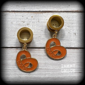 These adorable tunnel earrings feature classic enamel and antique gold pretzel charms, weighing approx 5 grams each, and measuring just over 4 cms from tip to tip.

This pair has been made with 1/2” gauge (12mm) surgical steel screw fit tunnels, to be worn in stretched lobes.