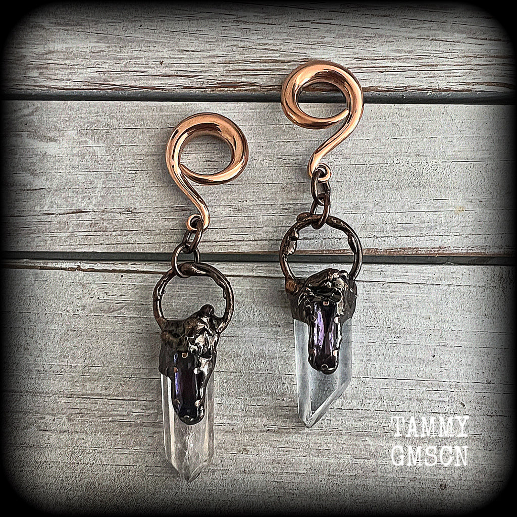 These clear quartz and amethyst gauged earrings are simply gorgeous!!
Featuring gorgeous amethyst stones sitting on front of chunky quartz pillars in an antique copper setting, these gauged earrings measure just on 9.5cms from tip to tip, and weigh approx 25 grams each.
This pair has been made on 6 gauge (4mm) surgical steel full curl hooks, suitable to be worn in stretched lobes.