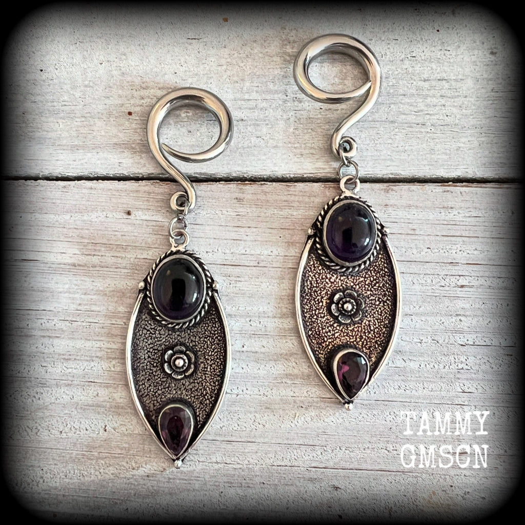 Featuring beautiful purple amethyst gemstones in a boho antique silver setting , this pair of earrings weighs approx 8 grams a piece and measure just under 8cms from tip to tip.

This pair have been made on 6 gauge (4mm) surgical steel full curl hooks, to be worn in stretched lobes.