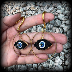 These unique evil eye gauged earrings feature a faux druzy greek evil eye, weighing approx 6 grams each, and are nice and dangly, hanging just on 7cms from tip to tip.

This pair have been made on 6 gauge (4mm) surgical steel full curl hooks, suitable for stretched lobes.