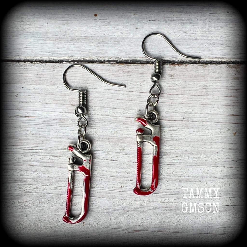 These awesome horror movie inspired earrings feature antique silver bone saws and adorned with b l o o d spatter, measuring approx 4cms from top to tip and weighing only a gram or two each.

This pair has been made with stainless steel french hooks, for pierced ears.