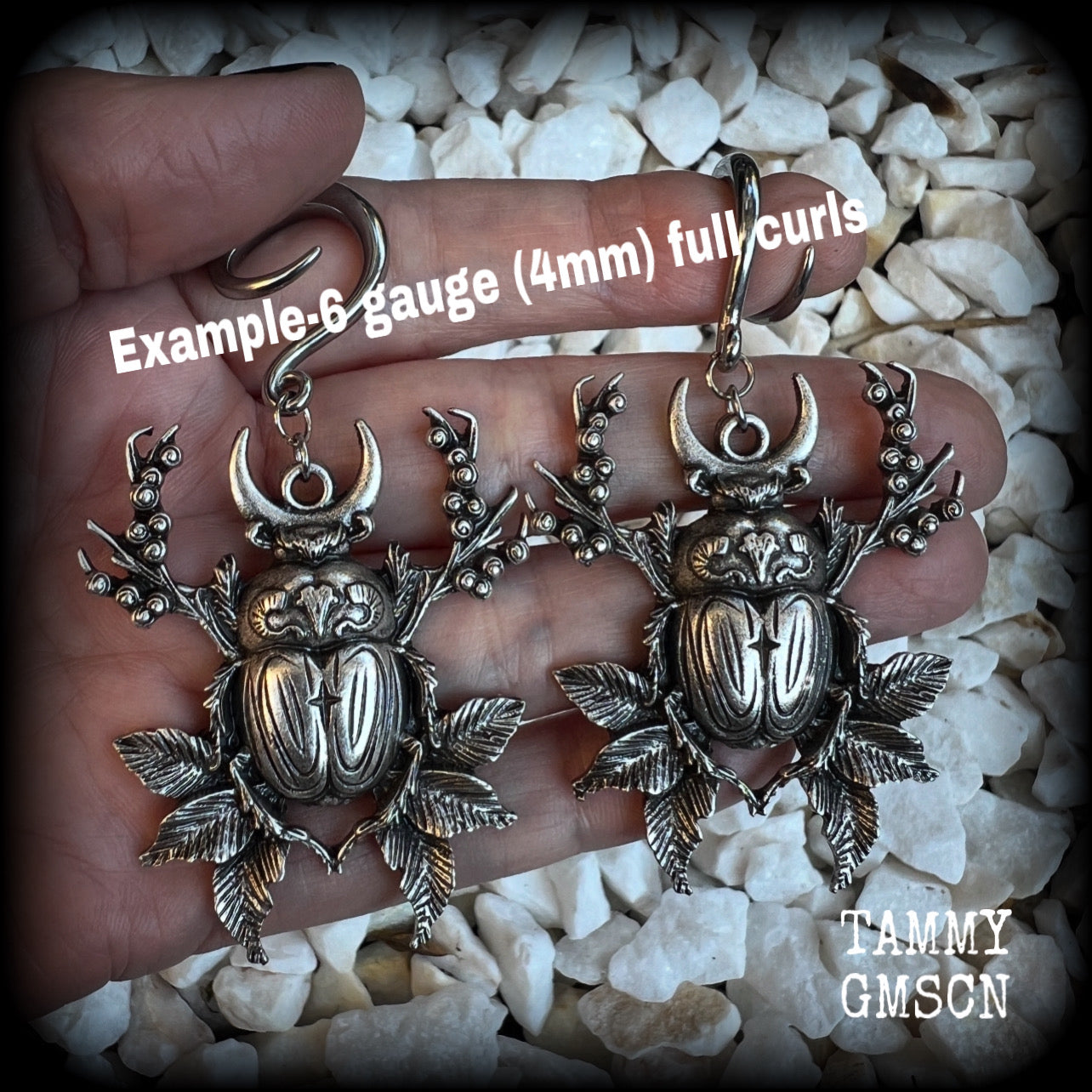 These gorgeous earrings feature large antique silver scarab beetles surrounded by berries and leaves with a crescent moon, measuring approx 7.5cms from tip to tip, and weigh 15 grams a piece.

This pair has been made on 6 gauge (4mm) gauge surgical steel full curls, to be worn in stretched lobes.