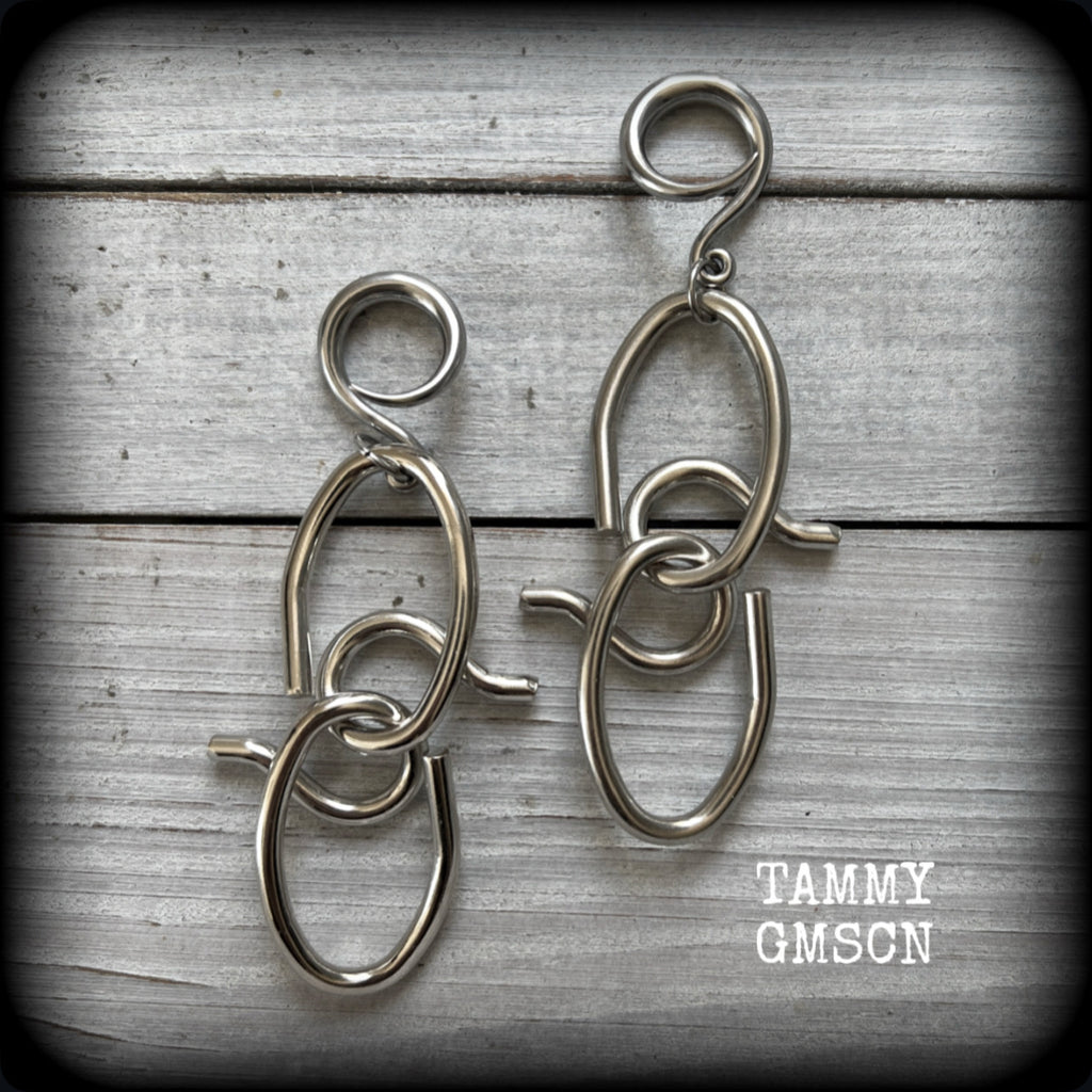 These awesome gauged earrings feature twisted and knotted surgical steel pieces, weighing approx 18 grams a piece, and nice and dangly at just over 9cms from tip to tip.

This pair has been made on 6 gauge (4mm) surgical steel full curl hooks, suitable for stretched lobes.