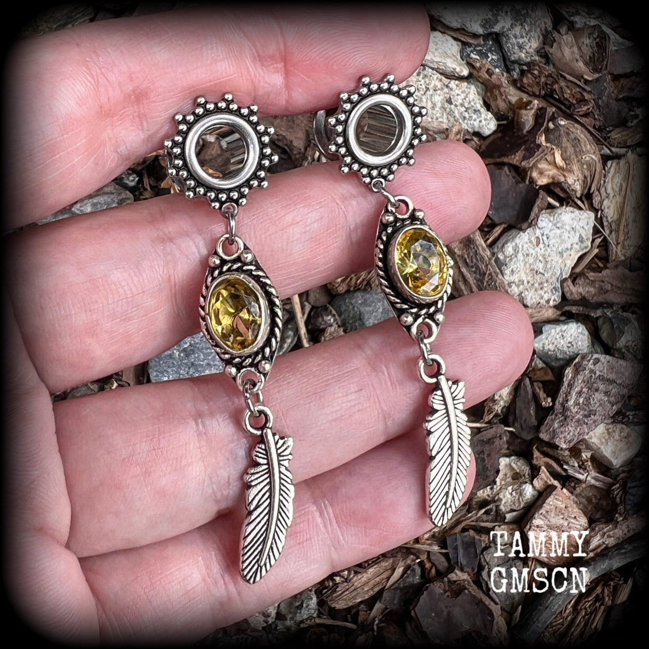 These beautiful boho tunnel earrings feature gorgeous antique silver feathers dangling from sparkly yellow citrine gemstones, weighing approx 6 grams each and measure 6.5cms from tip to tip.
This pair has been made with 0 gauge (8mm) gauge ornate surgical steel screw fit tunnels.