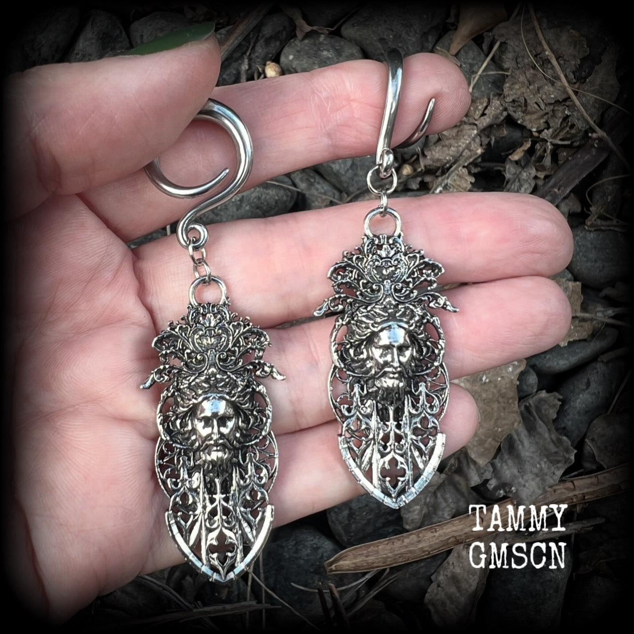 These gorgeous gothic antique silver gauged earrings feature beautiful baroque architecture with the face of Zeus-strong, commanding and masculine, depicted with flowing hair and moustache.

These earrings measure just on 8cms from tip to tip, and weighing approx 15 grams each.

This pair has been made on 6 gauge (4mm) surgical steel full curls, to be worn in stretched lobes.