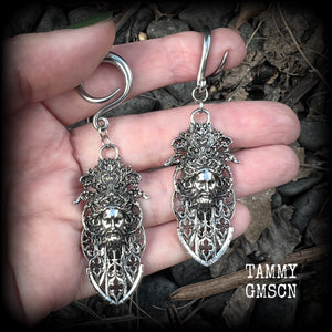 These gorgeous gothic antique silver gauged earrings feature beautiful baroque architecture with the face of Zeus-strong, commanding and masculine, depicted with flowing hair and moustache.

These earrings measure just on 8cms from tip to tip, and weighing approx 15 grams each.

This pair has been made on 6 gauge (4mm) surgical steel full curls, to be worn in stretched lobes.