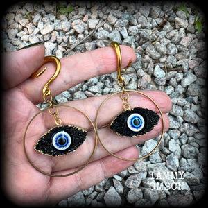 These unique evil eye gauged earrings feature a faux druzy greek evil eye, weighing approx 6 grams each, and are nice and dangly, hanging just on 7cms from tip to tip.

This pair have been made on 6 gauge (4mm) surgical steel full curl hooks, suitable for stretched lobes.