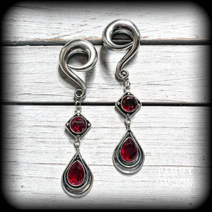 These beautiful dangly gauged earrings feature gorgeous deep red faceted garnet gemstones in an ornate antique silver setting, measuring just over 10cms from tip to tip, and weigh approx 27 grams each.

This pair have been made with 00 gauge (10mm) surgical steel full curl hooks, to be worn in stretched lobes.

