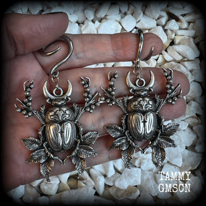 These gorgeous earrings feature large antique silver scarab beetles surrounded by berries and leaves with a crescent moon, measuring approx 7.5cms from tip to tip, and weigh 15 grams a piece.

This pair has been made on 6 gauge (4mm) gauge surgical steel full curls, to be worn in stretched lobes.