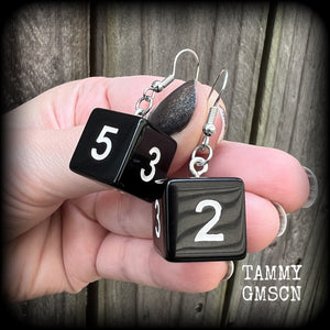 Featuring a pair of pitch black gamer dice, these super nerdy earrings measure just on 4cm from tip to tip and weigh approx 5 grams each.

This pair have been made with stainless steel french hooks, suitable for pierced ears.