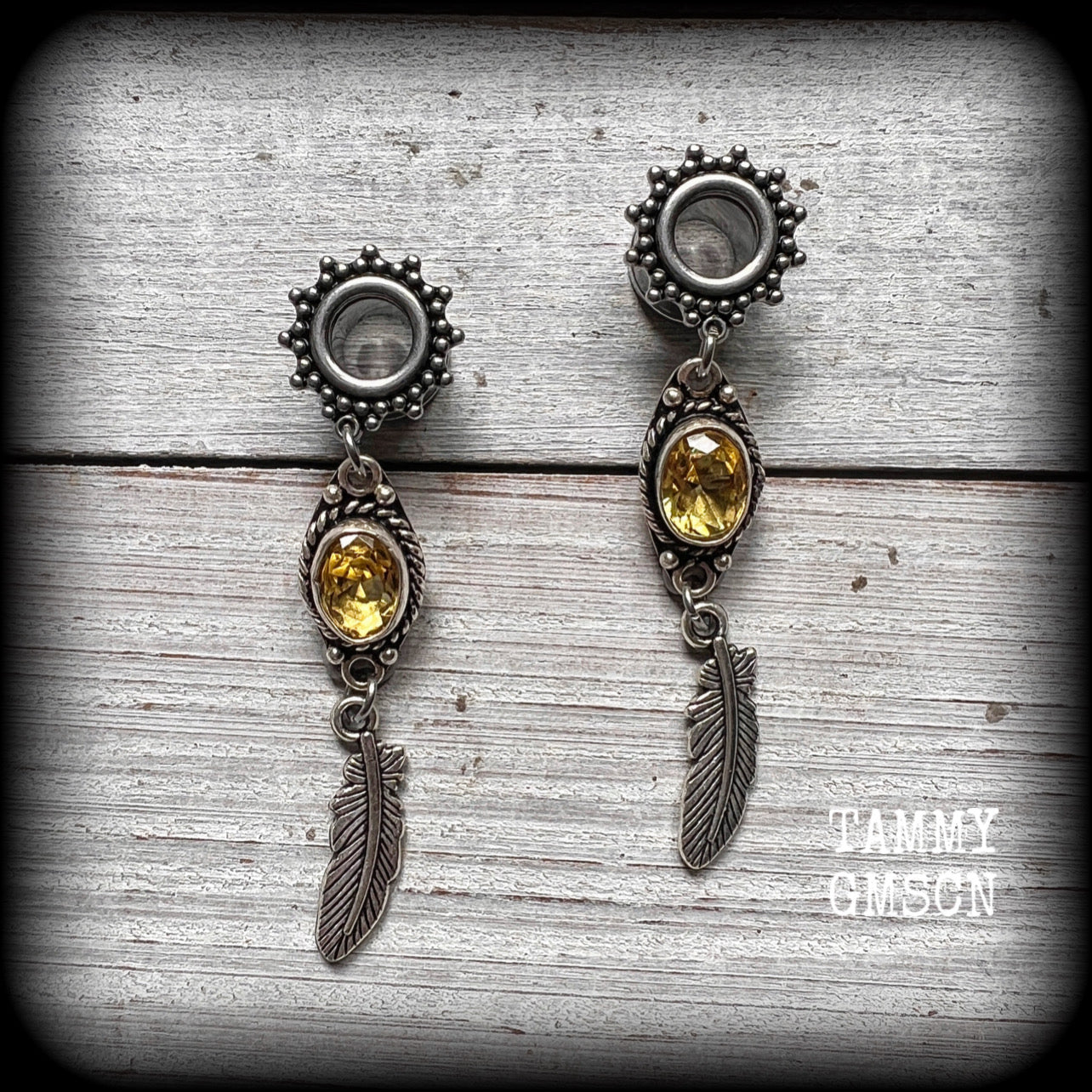 These beautiful boho tunnel earrings feature gorgeous antique silver feathers dangling from sparkly yellow citrine gemstones, weighing approx 6 grams each and measure 6.5cms from tip to tip.
This pair has been made with 0 gauge (8mm) gauge ornate surgical steel screw fit tunnels.