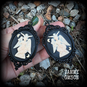 These gorgeous gothic earrings feature ivory Baphomets enclosed in beautiful black enamel framea, are light weight (11 grams a piece) and nice and dangly, measuring just over 8cms from tip to tip.

This pair has been made on stainless steel french hooks, suitable for pierced ears.

