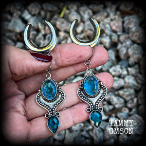 These earrings feature gorgeous facet blue topaz gemstones in a beautiful boho antique silver setting, lovely and dangly at just on 8cms from tip to tip, and not too heavy at 12 grams each.

These earrings have been made on 3/4” gauge (19mm) surgical steel cradles, to be worn in stretched lobes.