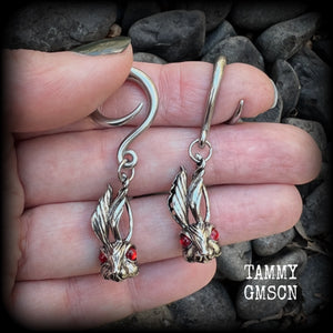Featuring super cute, slightly creepy antique silver zombie rabbits complete with red eyes, these earrings weigh 7 grams each, and are lovely and dangly at approx 5.5cms from tip to tip.

This pair has been made on 6 gauge (4mm) surgical steel full curl hooks, to be worn in stretched lobes.