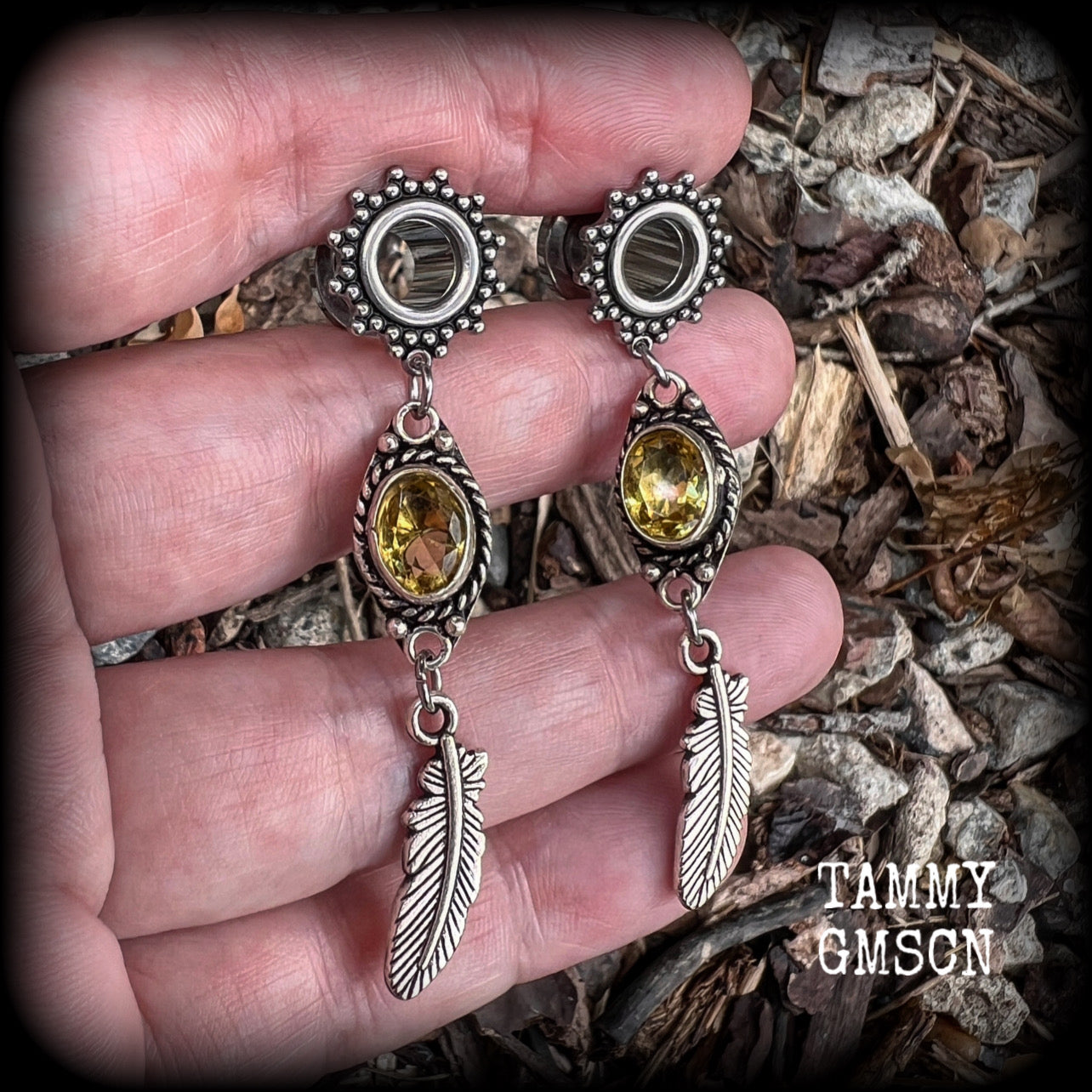 These beautiful boho tunnel earrings feature gorgeous antique silver feathers dangling from sparkly yellow citrine gemstones, weighing approx 6 grams each and measure 6.5cms from tip to tip.
This pair has been made with 0 gauge (8mm) gauge ornate surgical steel screw fit tunnels.