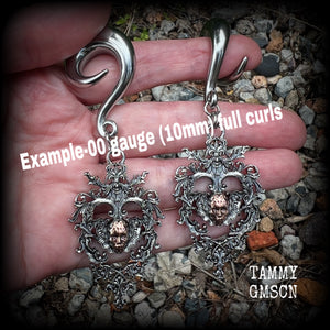 These gorgeous gauged earrings feature the face of a lost soul trapped within the bounds of beautiful baroque antique silver frames, measuring just under 9cms from tip to tip, and weighing approx 33 grams each.

This pair has been made on 00 gauge (10mm) surgical steel full curls, to be worn in stretched lobes.