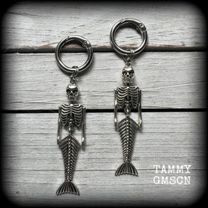 These gorgeous dangly earrings feature antique silver mermaid skeletons, measuring approx 10.5 cms from tip to tip, and weighing approx 14 grams a piece .

These earrings have been made on strong silver alloy snap hoop rings, to be worn in stretched lobes with silicone earlets from 2 gauge (6mm).