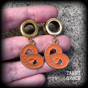 These adorable tunnel earrings feature classic enamel and antique gold pretzel charms, weighing approx 5 grams each, and measuring just over 4 cms from tip to tip.

This pair has been made with 1/2” gauge (12mm) surgical steel screw fit tunnels, to be worn in stretched lobes.