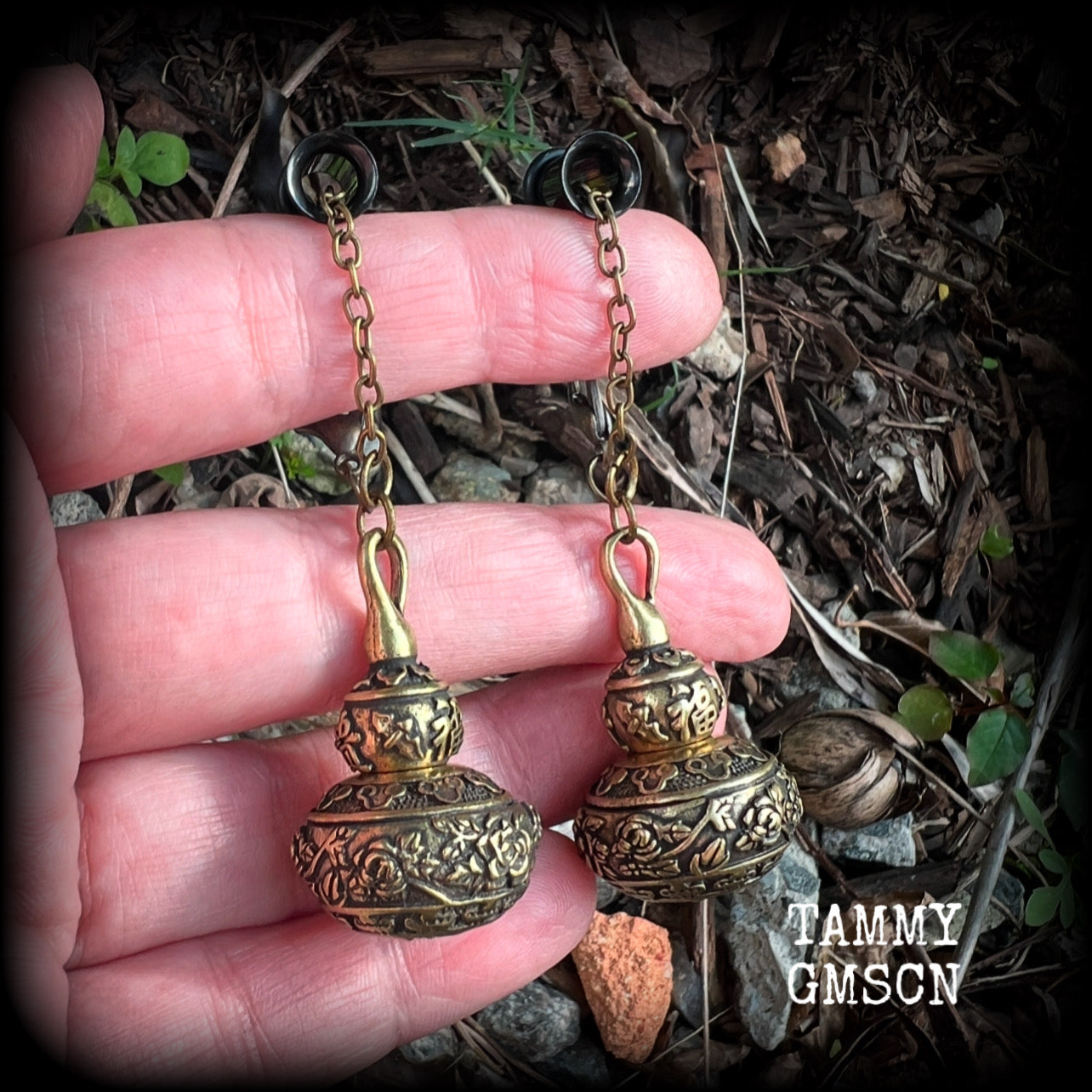 These brass stash pot tunnel dangles are gorgous! 
Featuring tibetan sanscrit and beautiful rose details, these earrings weigh in at approx 17 grams each, and nice and dangly, measuring in at just over 7cm from tip to tip.

These open up (as shown) so you can stash spell affirmations, drugs, precious pet ashes, anything you like really...

💥This listing includes one pair of surgical steel single flared O-ring earlets