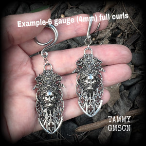 These gorgeous gothic antique silver gauged earrings feature beautiful baroque architecture with the face of Zeus-strong, commanding and masculine, depicted with flowing hair and moustache.

These earrings measure just on 8cms from tip to tip, and weighing approx 15 grams each.

This pair has been made on 6 gauge (4mm) surgical steel full curls, to be worn in stretched lobes.