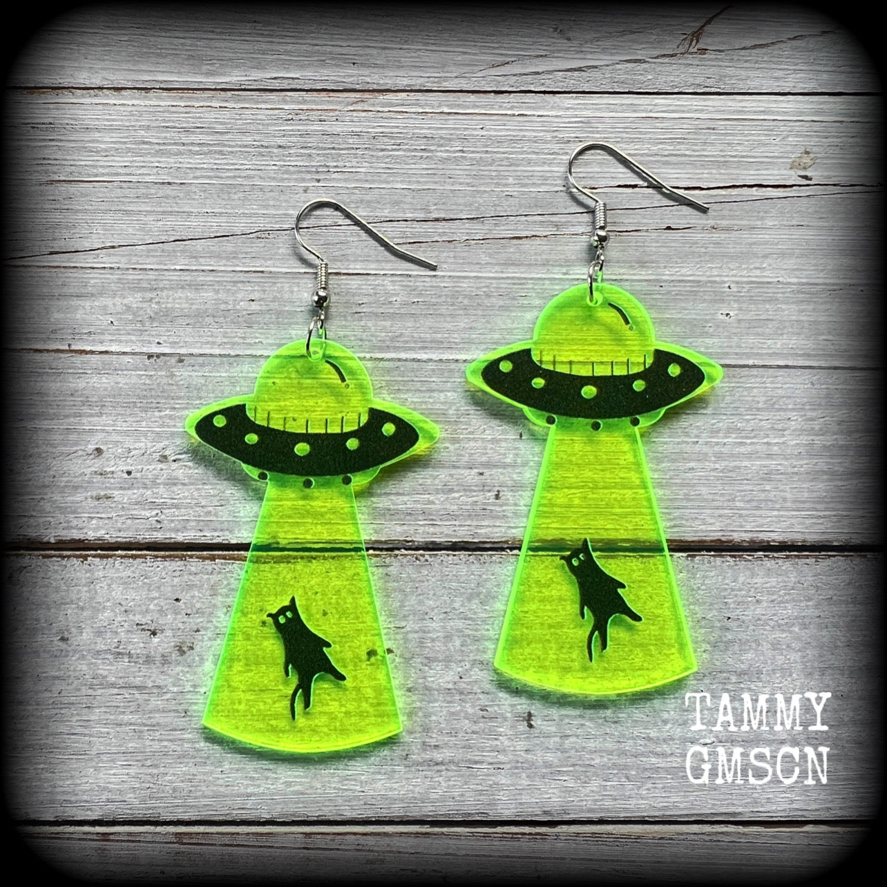 These super cute fluoro green and black earrings show an unsuspecting black cat being beamed up into a UFO!! 
Measuring 8cms from tip to tip, and weighing only 2 grams each (nice and light weight), this pair has been made on stainless steel french hooks, suitable for pierced ears.
