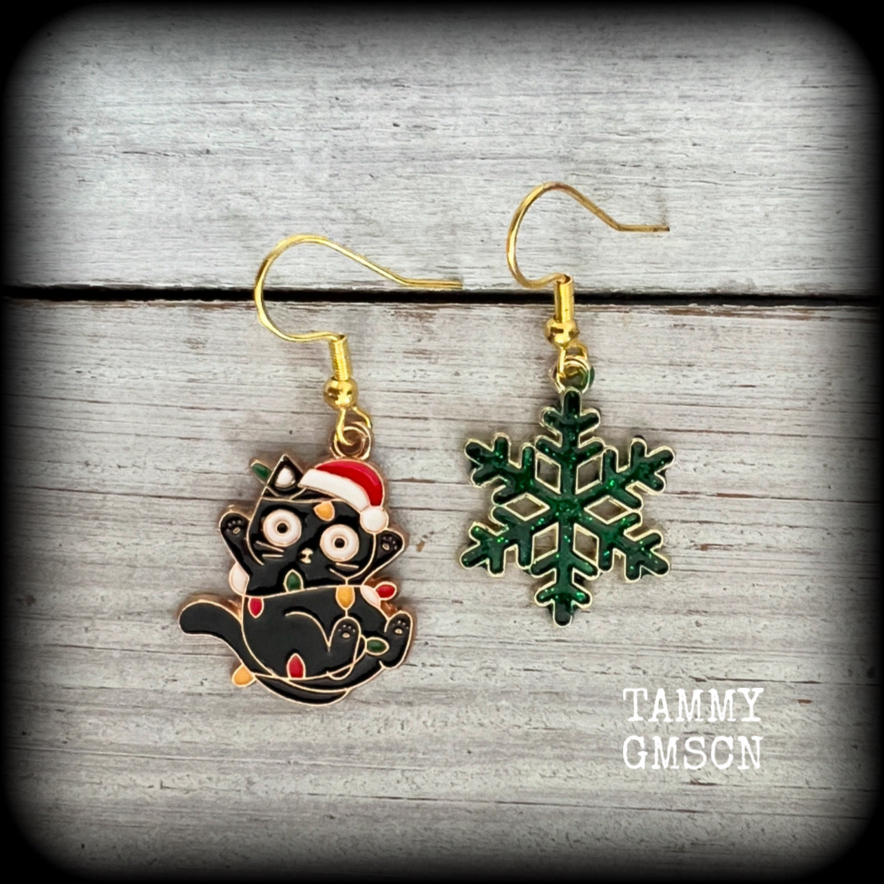 These adorable earrings feature a mischievous black cats entagled in Christmas decorations with glittering green snowflakes , measuring just on 4cms and weighing only a few grams each. 

This pair has been made on antique gold french hooks, for pierced ears.
