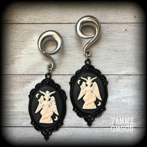 Featuring gorgeous ivory and black enamel Baphomet pendants, these gauged earrings measure just on 10.5cms from tip to tip, and weigh approx 32 grams each.

This pair have been made on 00 gauge (10mm) surgical steel full curls, to be worn in stretched lobes.