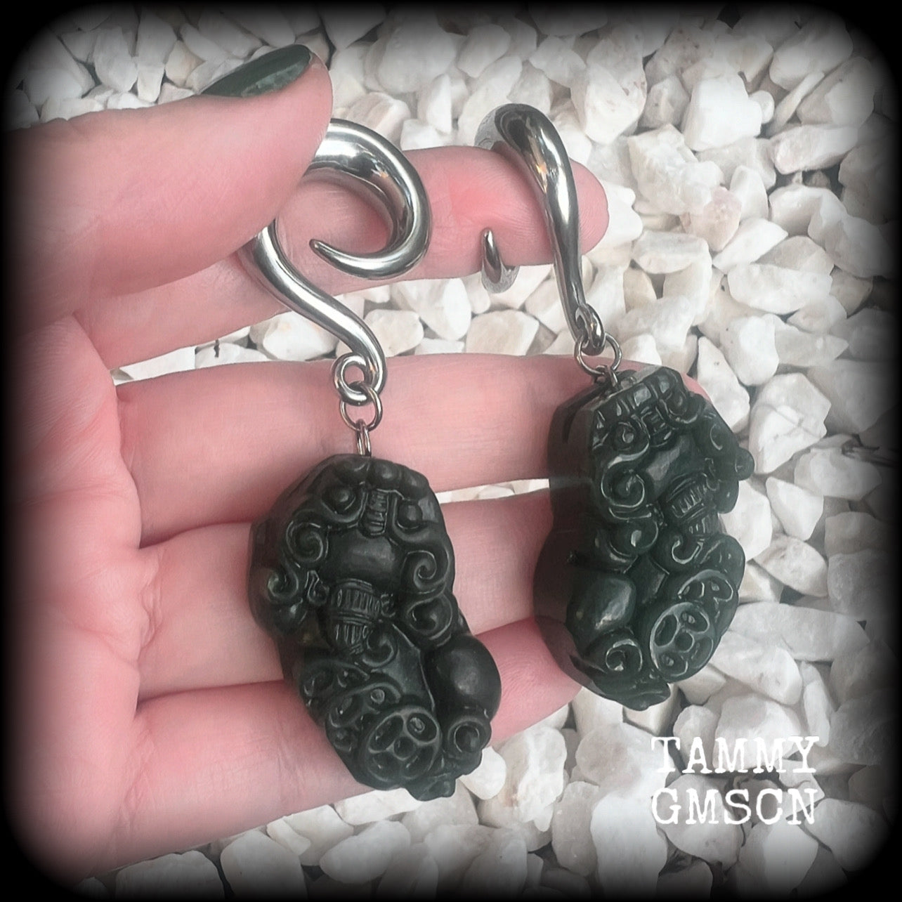 These gorgeous earrings are made from carved Lantian jade featuring the beautiful mythological lion dog, the Pi Xiu, weighing approx 34 grams a piece and measure just over 7cms from tip to tip.

This pair have been made with 0 gauge (8mm) surgical steel full curl hooks, to be worn in stretched lobes.
