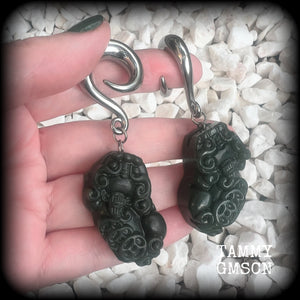 These gorgeous earrings are made from carved Lantian jade featuring the beautiful mythological lion dog, the Pi Xiu, weighing approx 34 grams a piece and measure just over 7cms from tip to tip.

This pair have been made with 0 gauge (8mm) surgical steel full curl hooks, to be worn in stretched lobes.