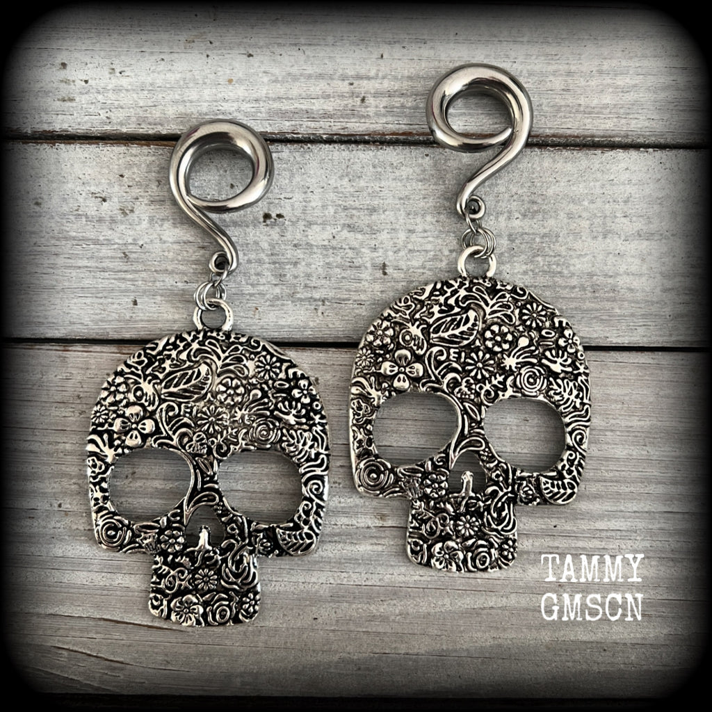 Featuring large antique silver skulls with floral detail, these earrings are perfect for Day of the Dead celebrations!

These gorgeous earrings weigh in at approx. 20 grams a piece, and nice and dangly at just under 10cms from tip to tip.

This pair of beautiful gauged earrings has been made with 2 gauge (6mm) surgical steel full curl hooks, suitable for stretched lobes.