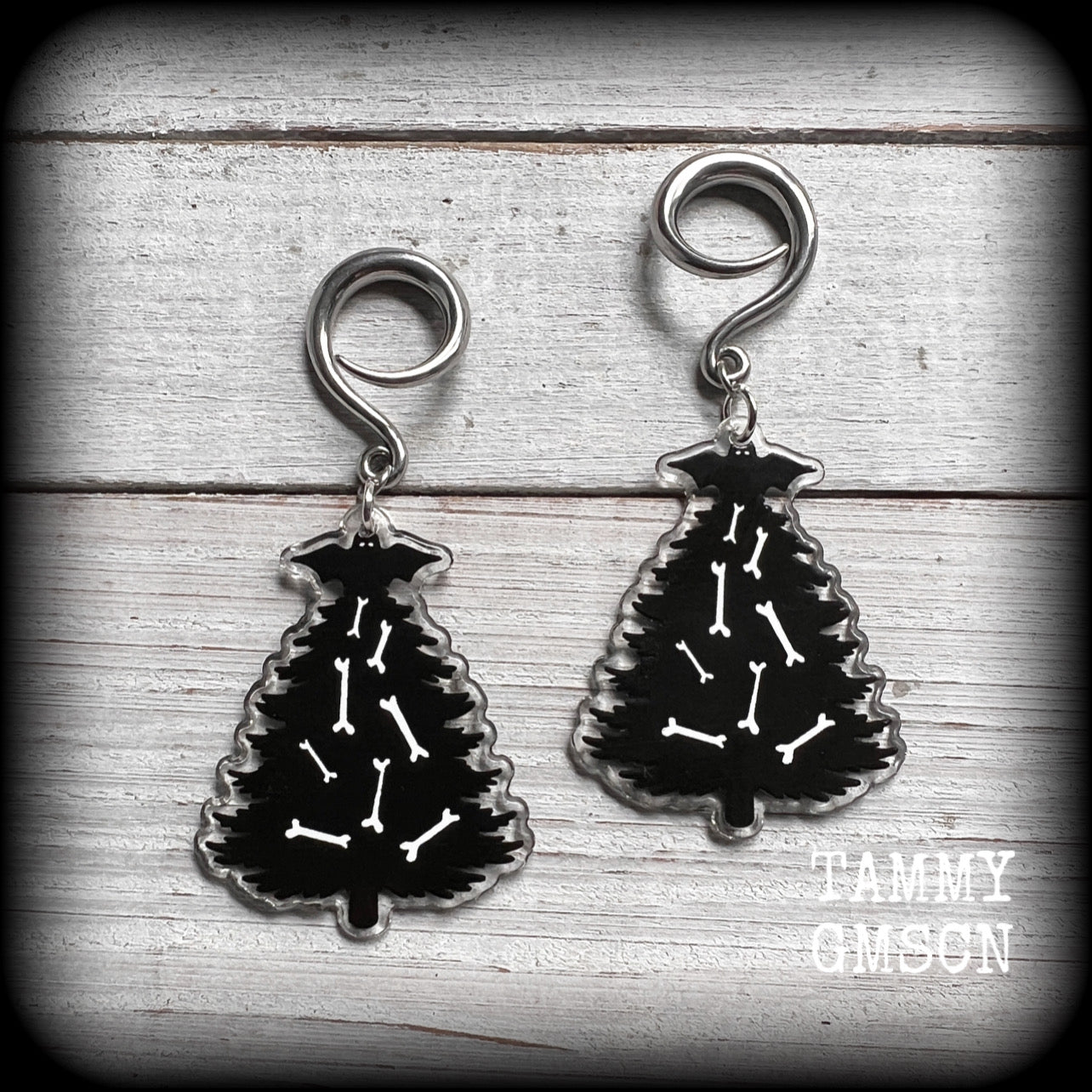 Featuring a spooky cute Christmas tree decorated with bones and topped with a black bat, these cute earrings weigh in at approx 5 grams a piece, and measure approx 7.5 cms from tip to tip.

This pair has been made on 6 gauge (4mm) surgical steel full curl hooks, to be worn in stretched lobes.