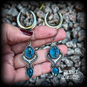 These earrings feature gorgeous facet blue topaz gemstones in a beautiful boho antique silver setting, lovely and dangly at just on 8cms from tip to tip, and not too heavy at 12 grams each.

These earrings have been made on 3/4” gauge (19mm) surgical steel cradles, to be worn in stretched lobes.