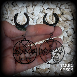 These gorgeous stainless steel earrings feature the Sigil of Lilith with the Sigil of Lucifer flanked by inverted pentagrams on each side. These earrings are lovely and light weight, weighing approx 9 grams each, and measure just on 7.5 cms from tip to tip.

This pair has been made on 3/4” gauge (19mm) surgical steel cradle hooks, to be worn in stretched lobes.